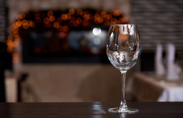 Empty clean wine glass with reflection on a blurred background with bokeh.