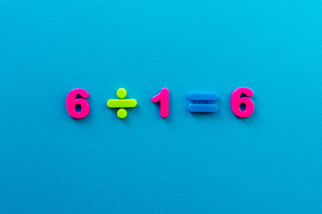 Fototapeta premium math action from colored plastic numbers on blue paper background