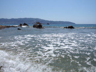 Interesting view of rocks at bay of ACAPULCO city in Mexico with Pacific Ocean waves on sandy beach...
