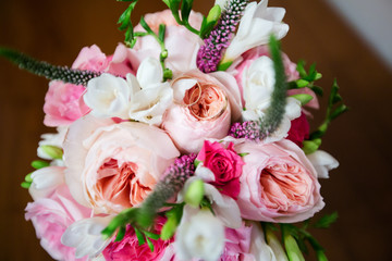 A pair of wedding rings on a bouquet of colorful flowers, close up shot