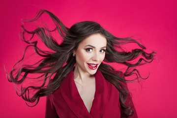Girl in shock on pink background. Young beautiful woman with hair up.