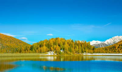 autumn landscape in Ultental ( Ultimo Valley) with a trees in autumn colors.the little Lake Fontana Bianca at almost 1,900 m a.s.l.,Dolomites, South Tyrol, province of Bolzano, Italy, Europe.