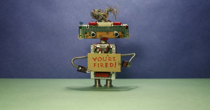 The most important robot boss dismisses personnel. The robot head looks in different directions and shows a cardboard sign with the inscription You are fired. Blue green background. Stop motion style