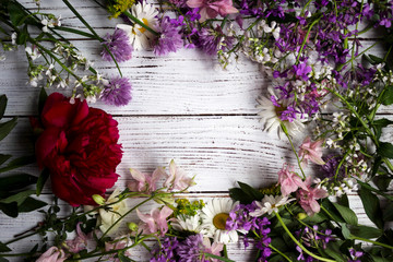 Red, white and lilac flowers on white wooden background, Flatley