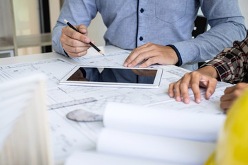 Construction engineering or architect discuss a blueprint while checking information on drawing and sketching meeting for architectural project in work site