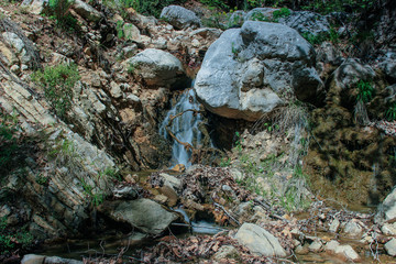 a small waterfall with clean drinking water in the rocks. natural background