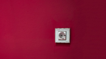 Fototapeta na wymiar a white socket on the red wall