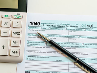 New 2019 IRS 1040 tax form, instructions, pen and calculator