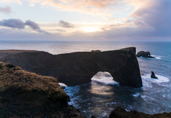 Dyrholaey rock arch in southern Iceland during sunrise.