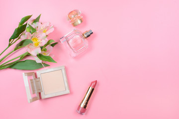 Cosmetics and flowers on a pink background. Beauty concept.
