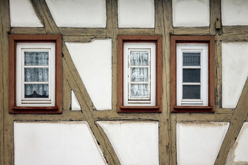 Old ancient wooden window with blinds or shutters. Scenic original and colorful view of antique windows in old city Sindelfingen, Germany. Isolated on wall. No people. Front view. Old fashioned style. - 243027320