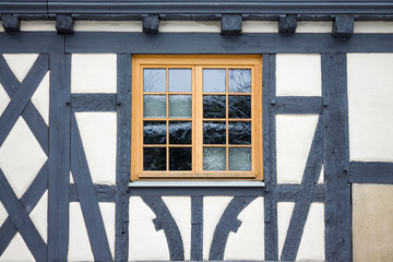 Old ancient wooden window with blinds or shutters. Scenic original and colorful view of antique windows in old city Sindelfingen, Germany. Isolated on wall. No people. Front view. Old fashioned style. - 243027559
