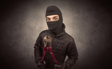 Burglar standing in black clothes and balaclava on his head.