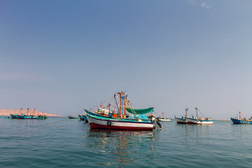 Fototapeta na wymiar Colorful fishing boats anchored at the pier of Paracas, Peru
