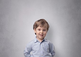 Fototapeta premium Adorable little boy portrait with empty grey wall background