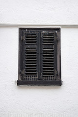 Old ancient wooden window with blinds or shutters. Scenic original and colorful view of antique windows in old city Sindelfingen, Germany. Isolated on wall. No people. Front view. Old fashioned style. - 243028300