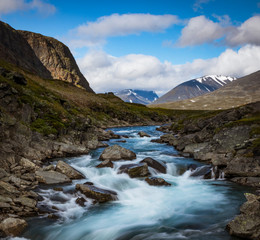 Naklejka na ściany i meble Flowing water in a river during the hike of Kungsleden (Kings path) in northern Sweden. 