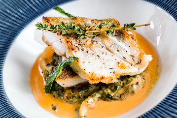 Fried fish fillet. Cod with sauce and herbs