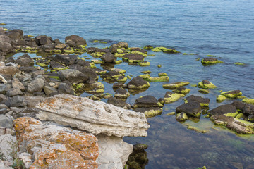Multi-colored sea stones. Large stones in the sea or ocean. Seascape. Stone mound. The Black Sea coast in Nessebar. Nature of Bulgaria. Euro-trip. Cobblestones in the water.