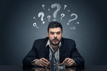 Young drunk disappointed man with question signs concept
