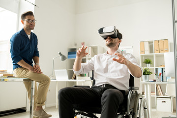 Two young business partners working in team and using virtual reality headset at modern office