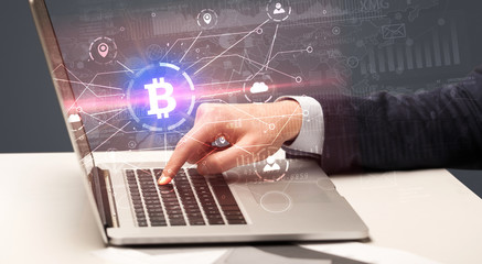 Hand checking on laptop global bitcoin exchange rate concept
