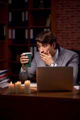 Businessman working late in office with candle light