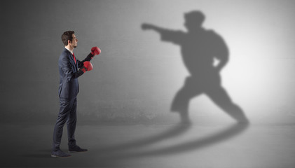 Businessman fighting with his strong karate man shadow
