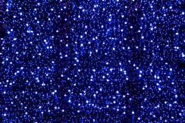 Abstract blurred background with bokeh blue Christmas lights of various sizes