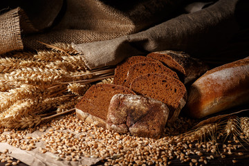 Assortment of baked bread on wooden table background