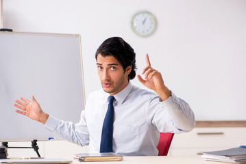 Young handsome financial speciaist in front of white board 