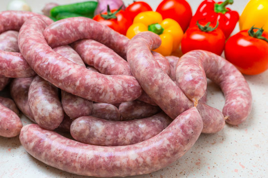 Assorted raw sausage for barbecue with vegetables.