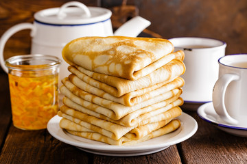 Homemade thin crepes stack, wrapped pancakes on wooden rustic table