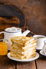 Homemade thin crepes stack, wrapped pancakes on wooden rustic table