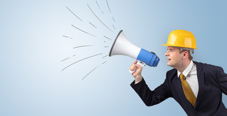 Fototapeta premium Young architect constructor yelling with megaphone and copyspace 