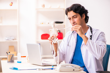 Young male doctor with skeleton 
