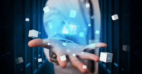 Person holding hologram projection displaying white cubes in server room
