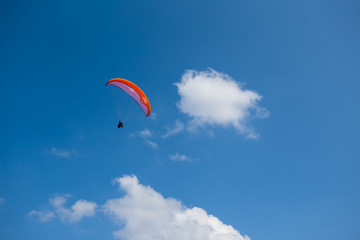 paraglider fly among a blue sky