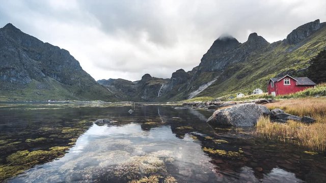 4k Timelapse movie film clip of Bunes sand beach with view to traditional fisher hut at Bunes Fjorden at Lofoten Islands in Norway on a blue sky with clouds sunny day.