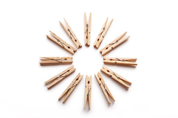 Wooden clothespins arranged in a circle isolated on white background.