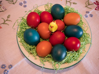 easter eggs in basket on flowered tablecloth