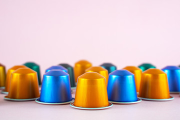 Colorful collection of espresso coffee machine capsules  on pink background.