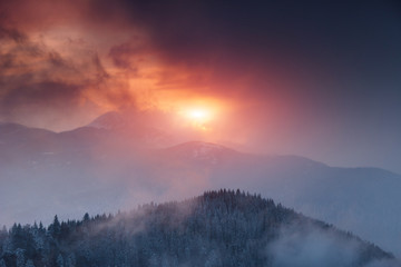 Dramatic winter landscape in mountains at sunset. Fantastic wintry scene.View of colorful sky glowing by sunlight. National Park Carpathian. Ukraine. Europe.