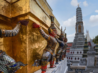 Fototapeta premium Esculturas de demonios sostienen Phra Borom Maha Ratcha Wang o Gran Palacio Real en Bangkok, Tailandia