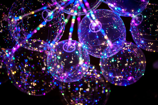 LED balloon with multi-colored luminous garland. Colorful LED incandescent light lamp on the surface of balloon on the black background.Beautiful blur bokeh pattern for abstract background