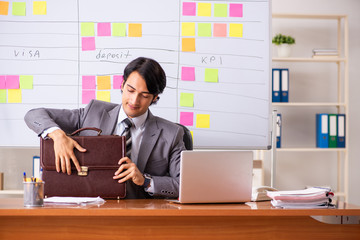 Young handsome employee working in the office