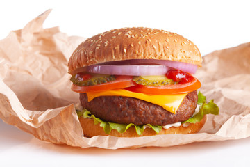 Hamburger in wrapping paper on white background.
