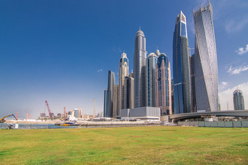 Fototapeta na wymiar Luxury Dubai Marina skyscrapers and nature around green park, United Arab Emirates