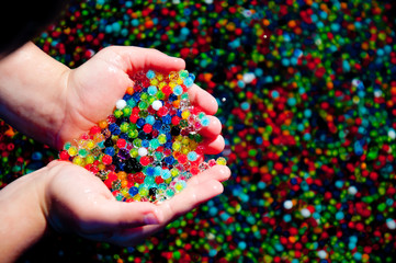 multicolored water beads in child's hands