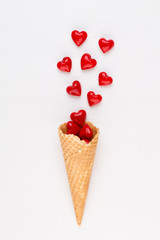 Creative composition for Valentines day with waffle cone, mixed hearts on white background top view. Fashion flat lay.